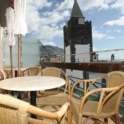 a table and chairs on a balcony in Hotel Catedral in Funchal Madeira
